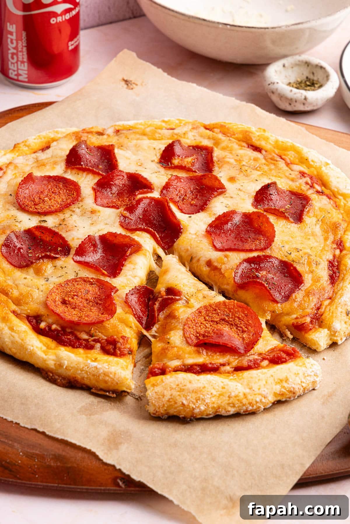 Cottage cheese pizza with pepperoni on top sitting on a piece of brown parchment paper 