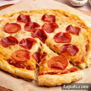 Cottage cheese pizza with pepperoni on top sitting on a piece of brown parchment paper