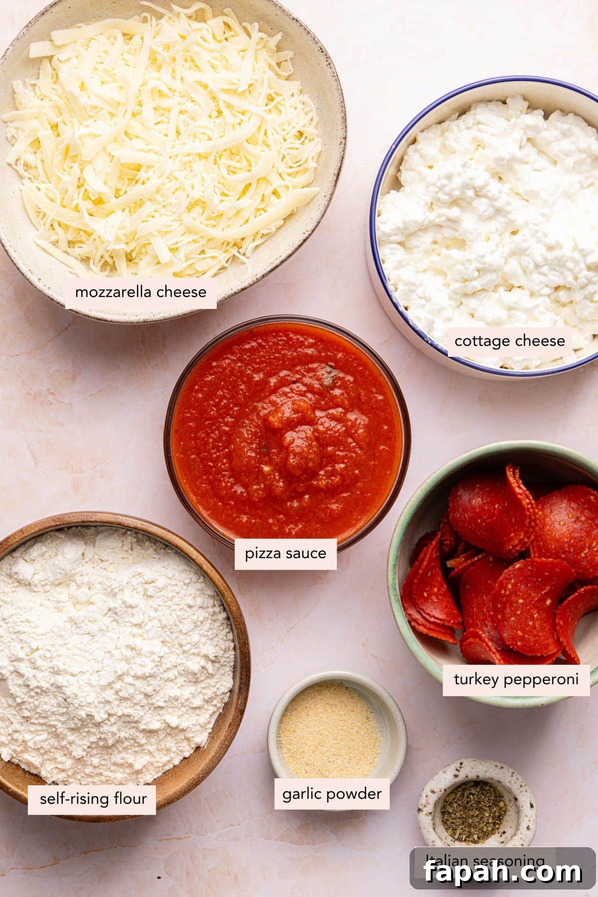 All of the ingredients for cottage cheese pizza in bowls on a countertop.