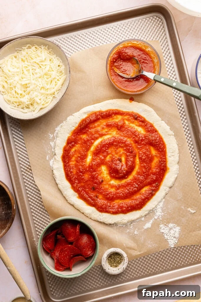 The sauce spread on top of the round crust before baking.