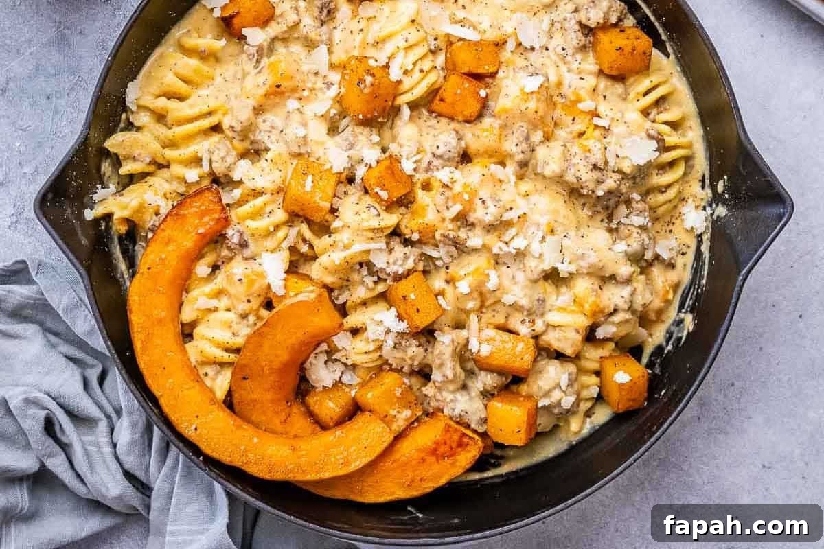 a skillet with pasta, butternut squash, and creamy ground beef.