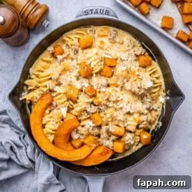 Butternut Squash Pasta served in a pan, with melted cheese and roasted squash glistening on top.