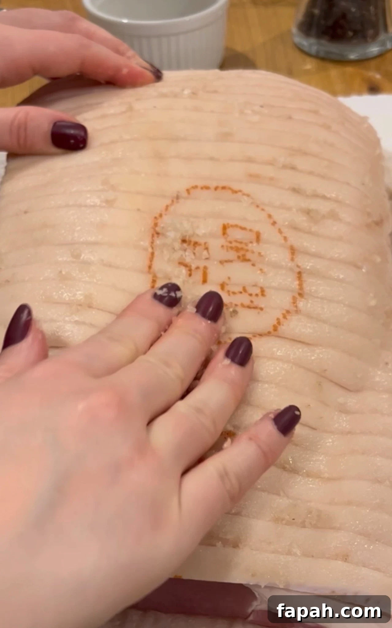 Rubbing salt in between the rind of the pork roast.