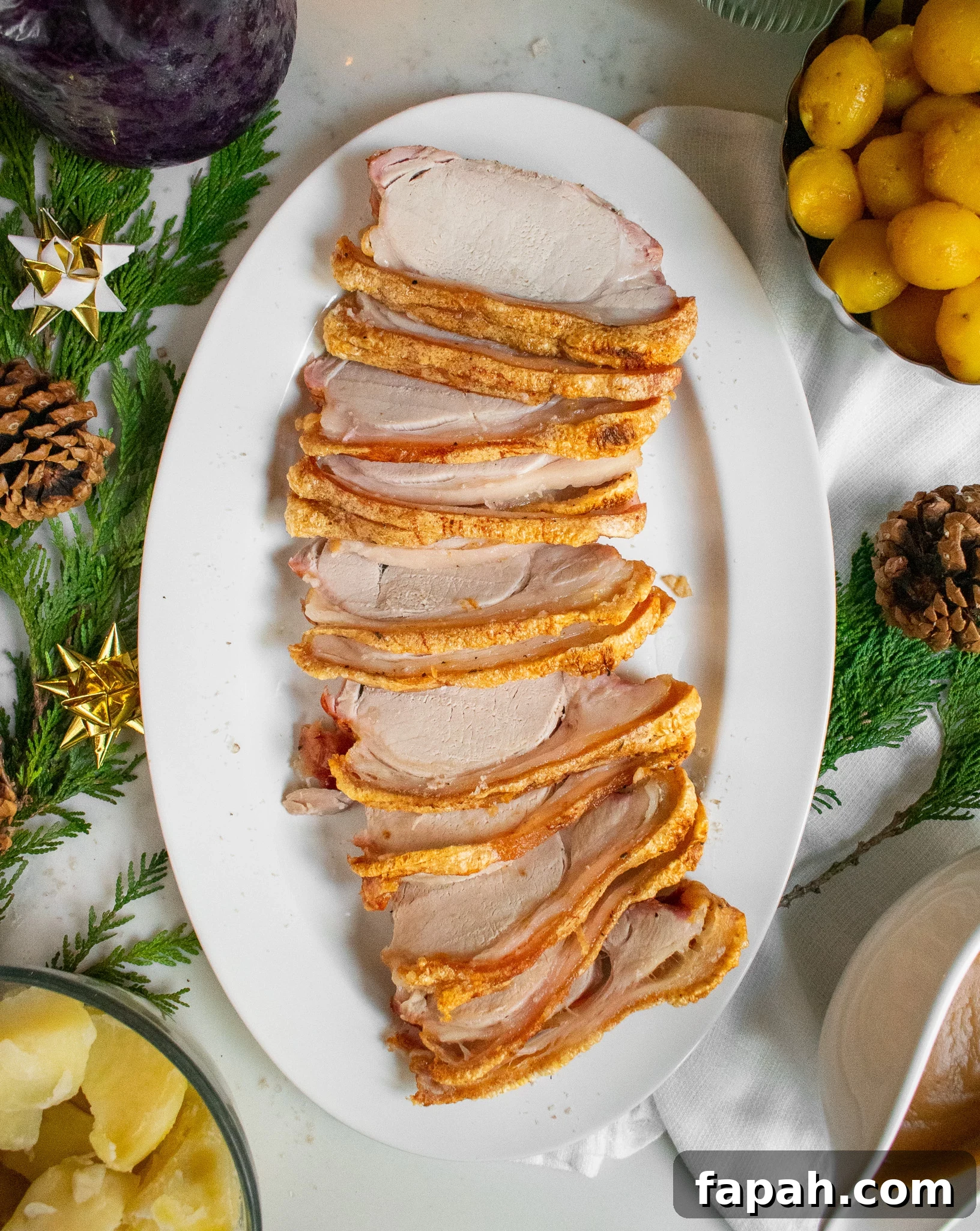 Slices of roast pork loin with crackling on a serving dish.