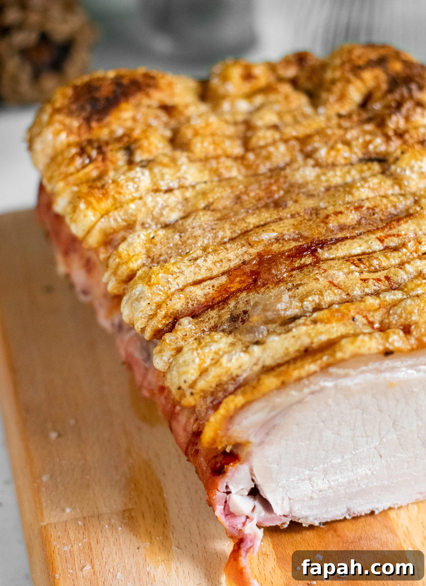 A roast pork loin with crackling on a cutting board.