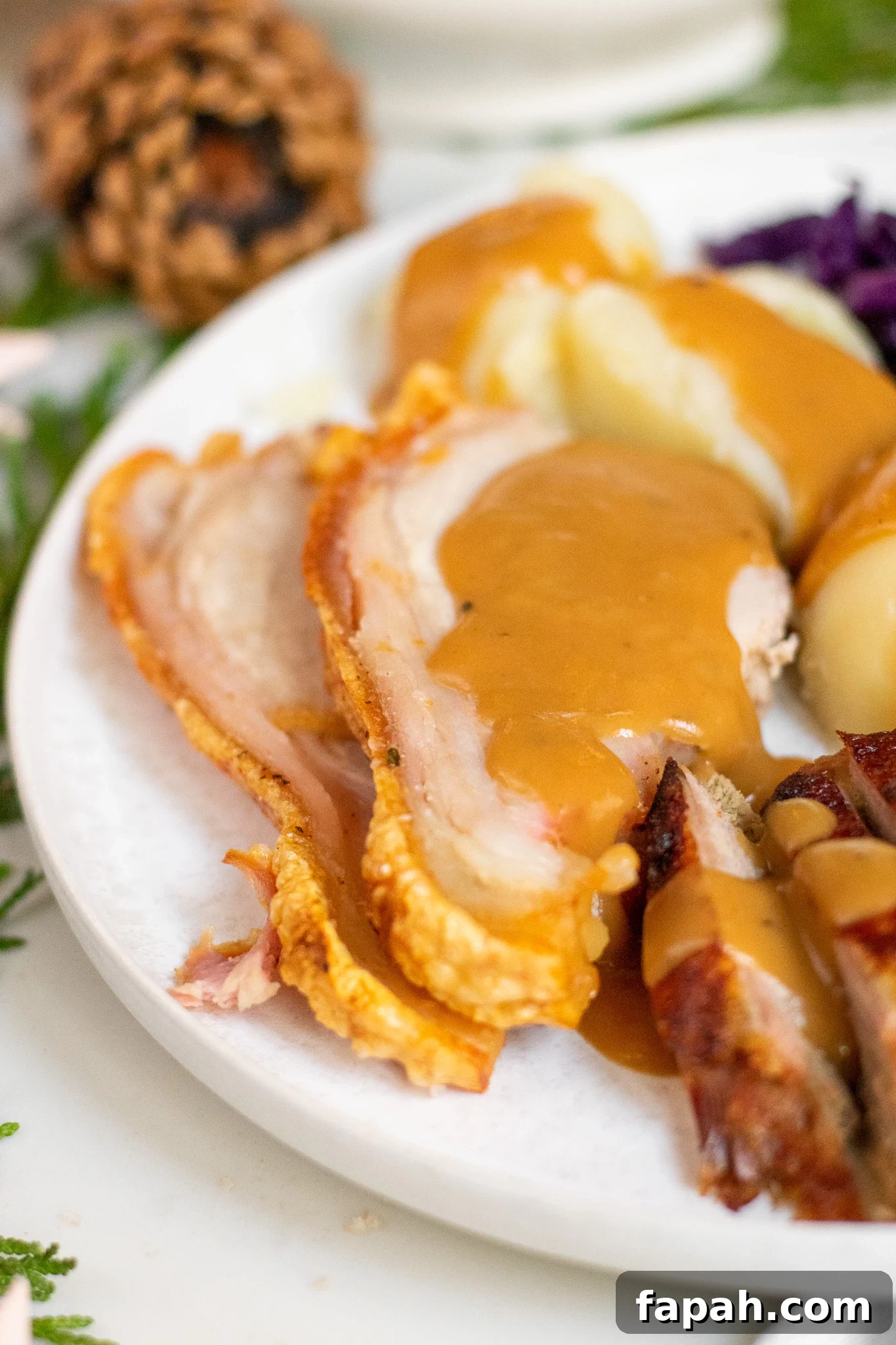 Slices of roast pork topped with gravy.