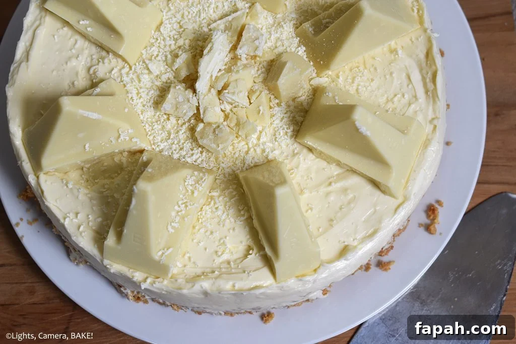 Top view of half of the White Chocolate Toblerone Cheesecake on a white plate with a wood board background.