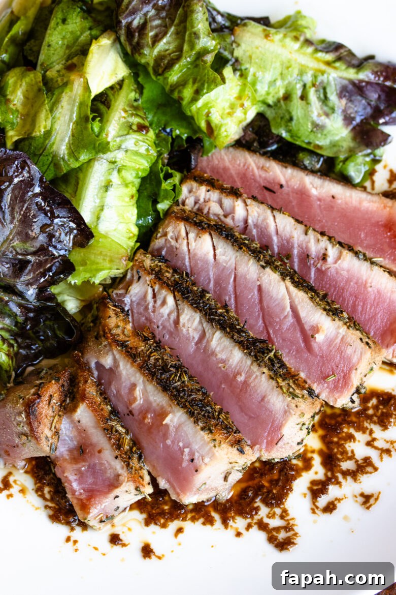 Sliced tuna steak served with salad. 