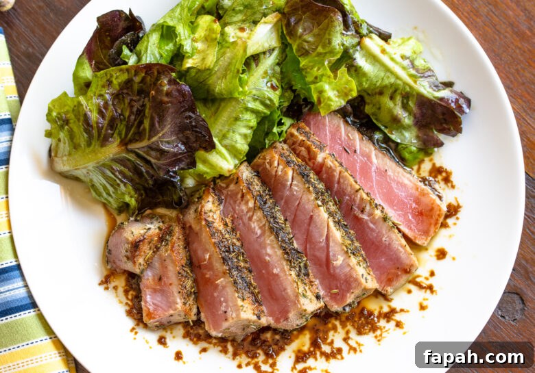 Tuna steak fanned out on a white plate.