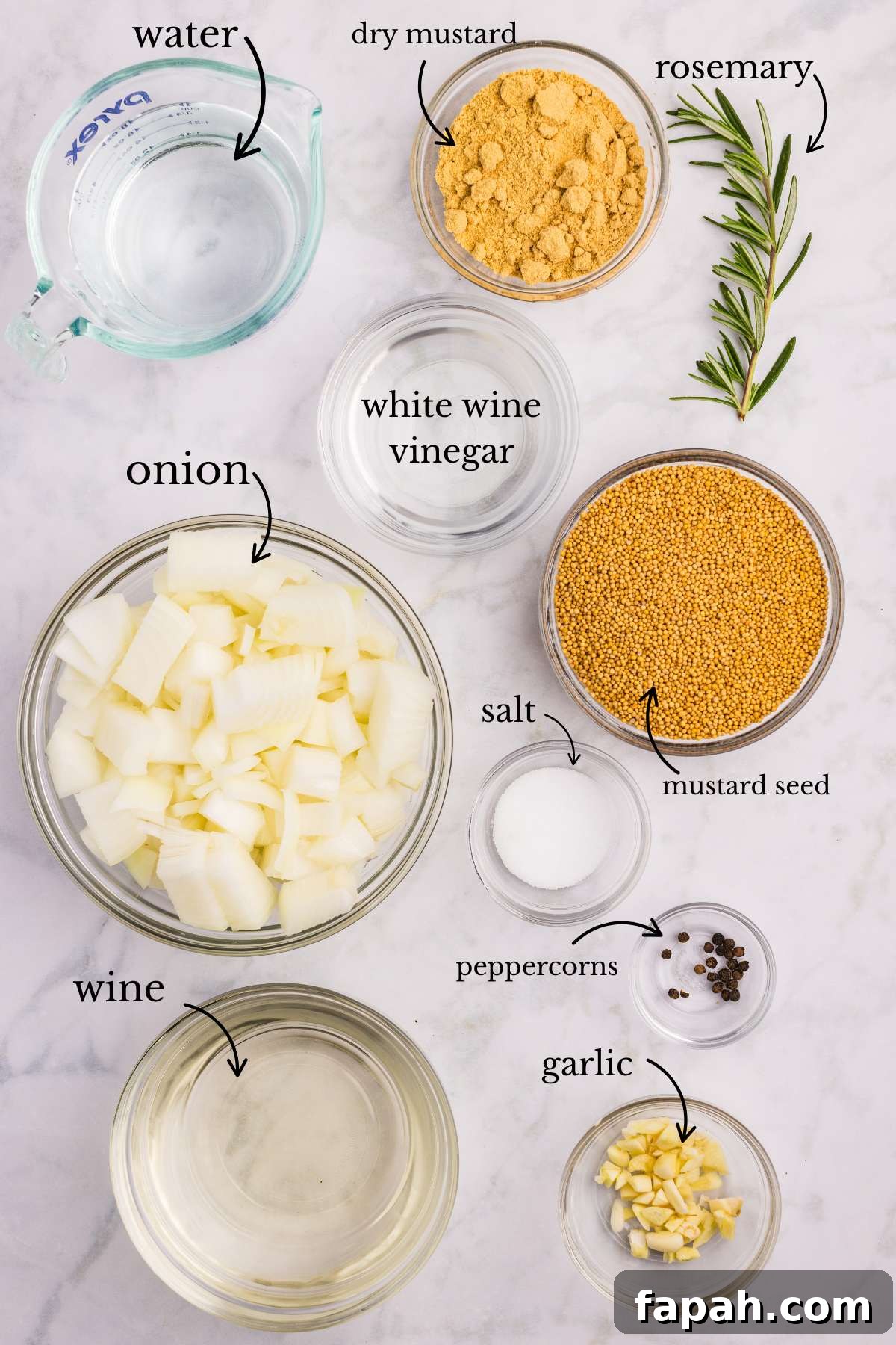 Ingredients for Dijon mustard laid out in bowls including wine, onions, and spices.