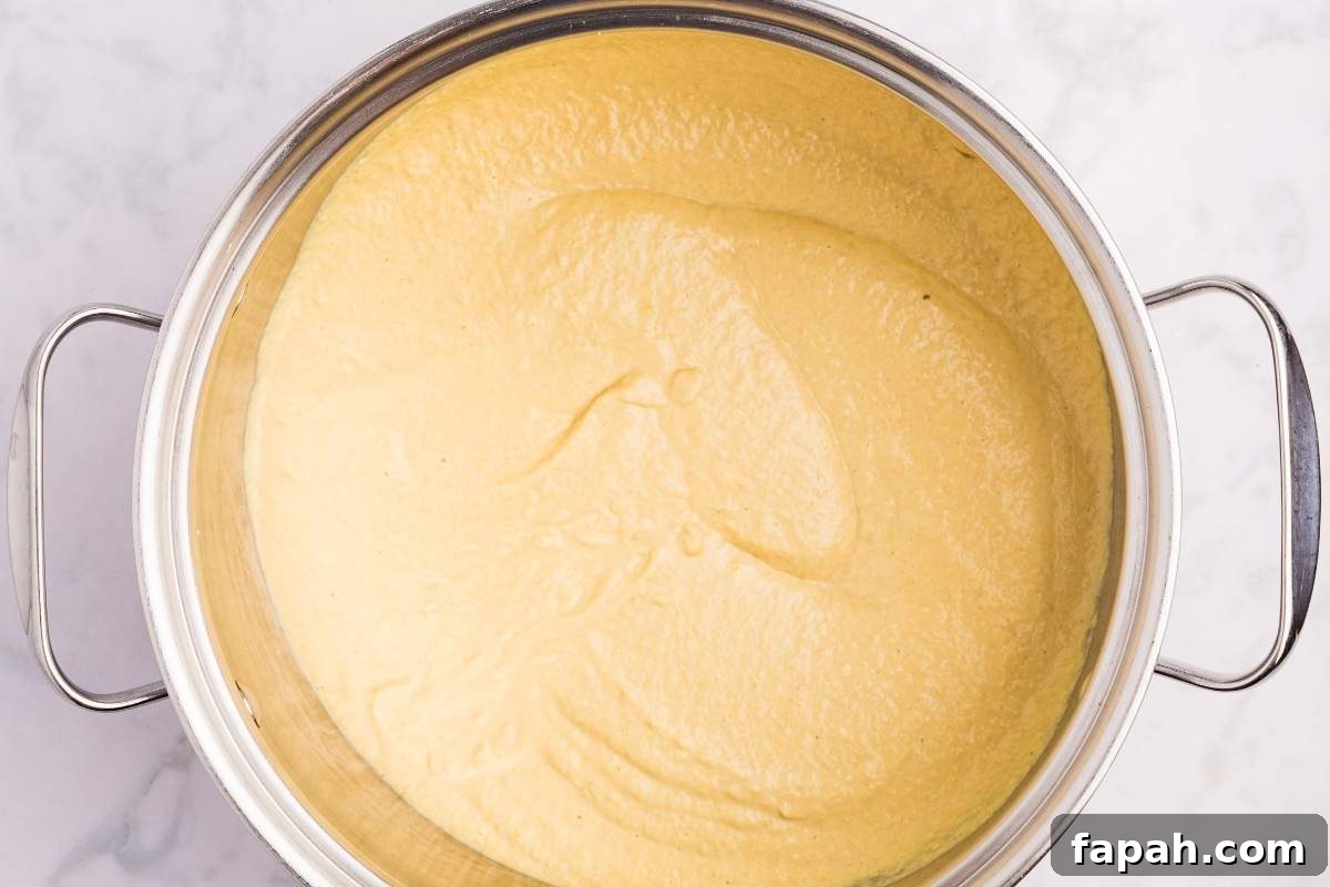 Large pot with smooth yellow mustard mixture ready for final cooking.