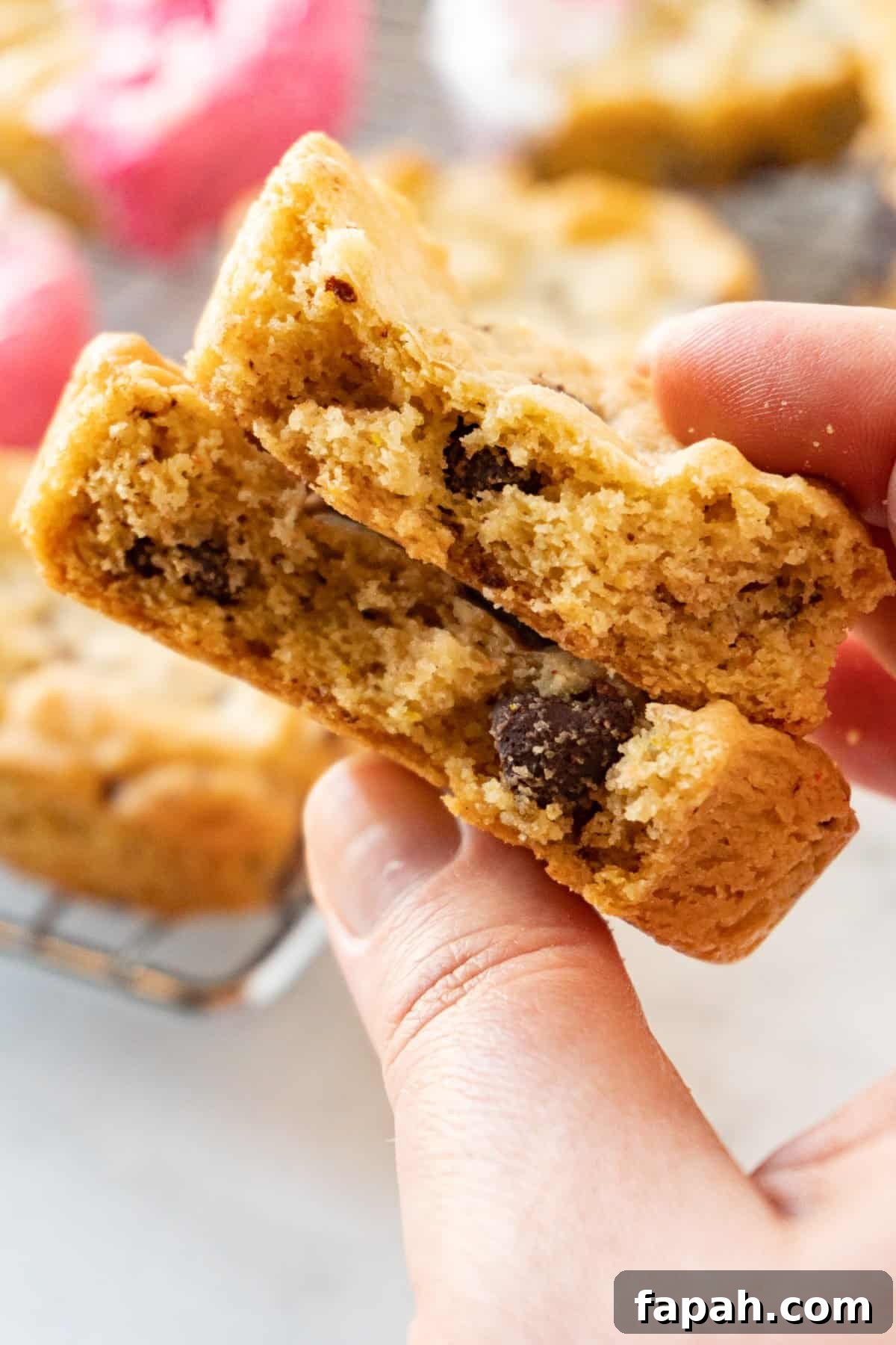 Heart-Shaped Cookies Recipe for Valentine’s Day 13 heart shaped chocolate chip cookie in half in hand