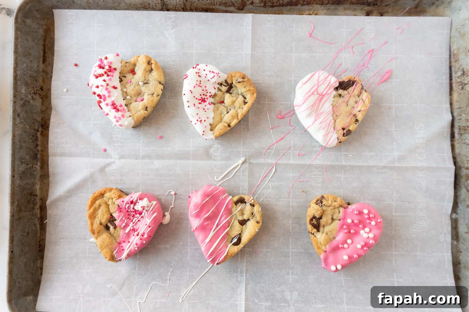 Heart-Shaped Cookies Recipe for Valentine’s Day 9 heart shaped chocolate chip cookies decorated on baking sheet.