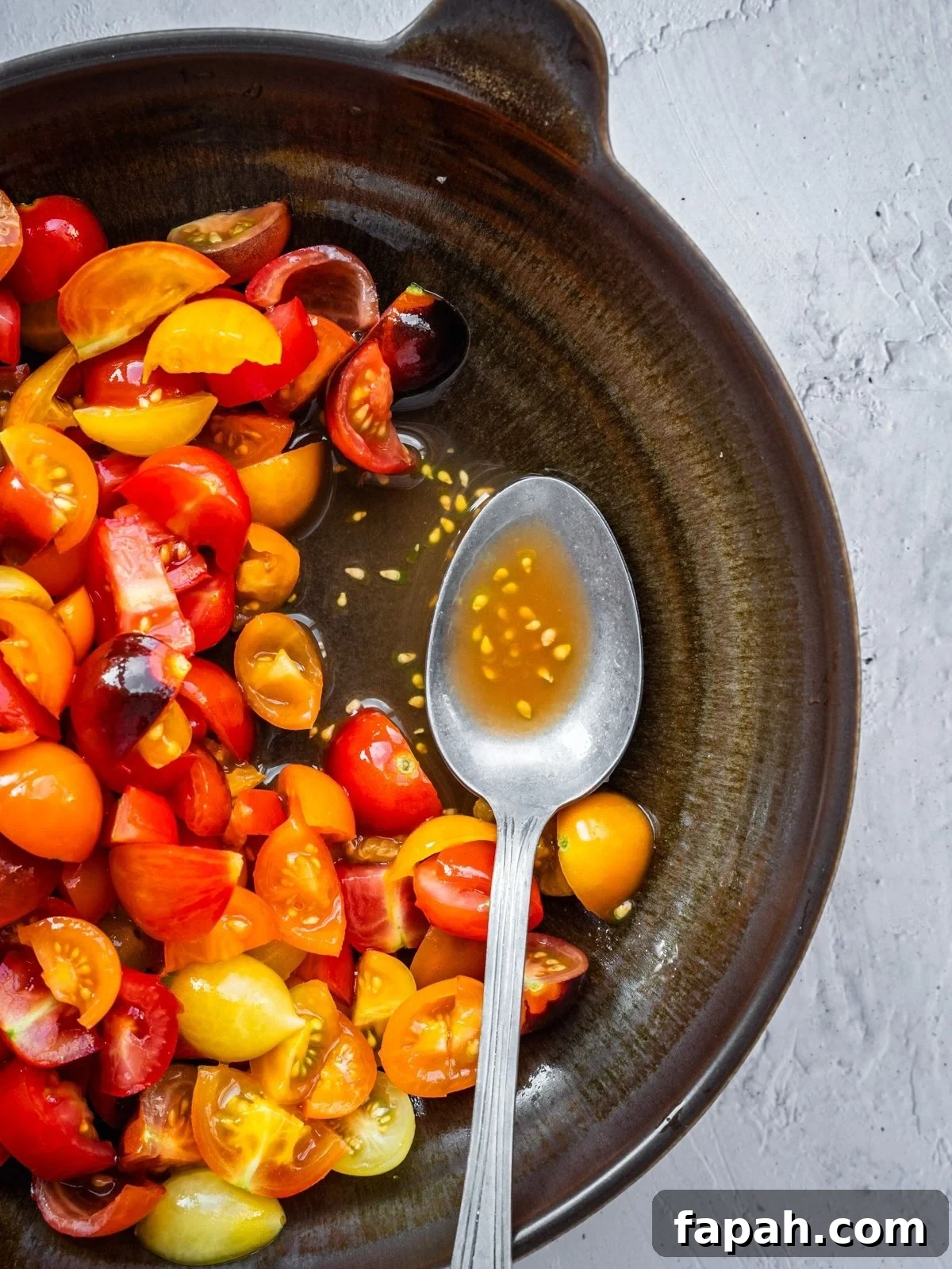 Fresh Cherry Tomato Pico de Gallo Salsa Recipe 5 Sliced cherry tomatoes after getting salted and rested showing the liquid at the bottom of the bowl.
