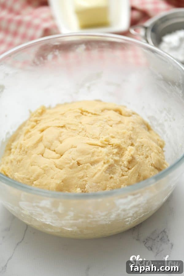 Glass mixing bowl with sugar cookie dough inside, by Skip to my Lou.