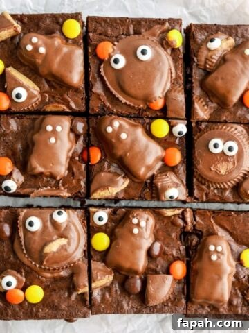 Brownies with peanut butter cup faces on top cut into slices.