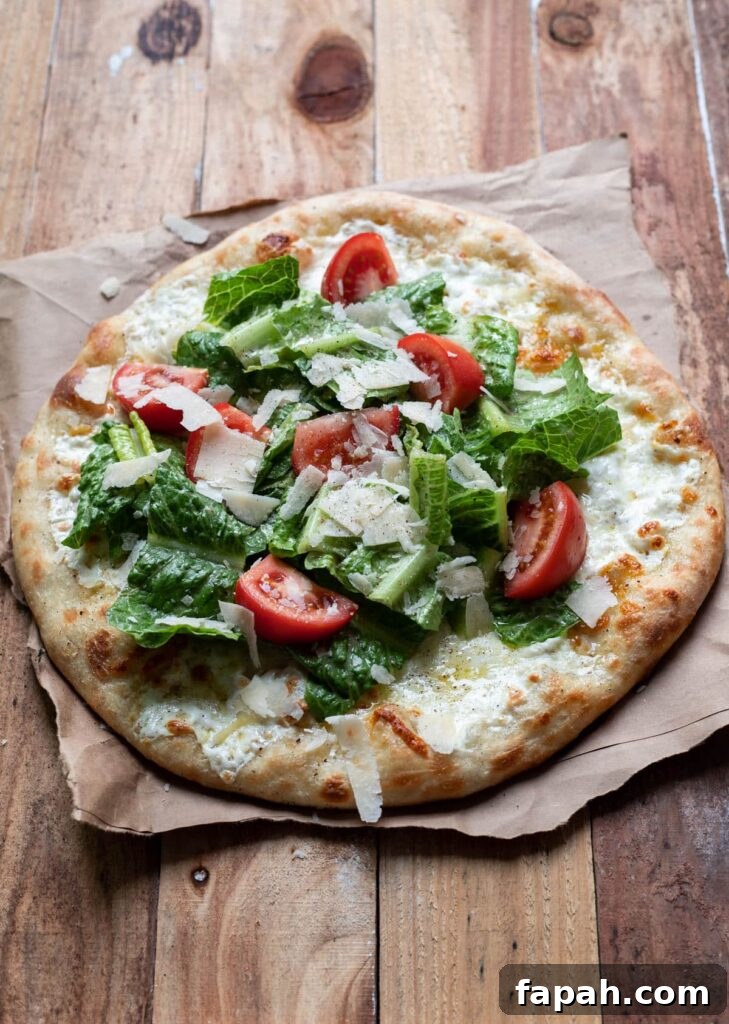 Caesar Salad Pizza Recipe: Crispy Romaine & Parmesan Pizza 2 cheese pizza with caesar salad and tomatoes on top