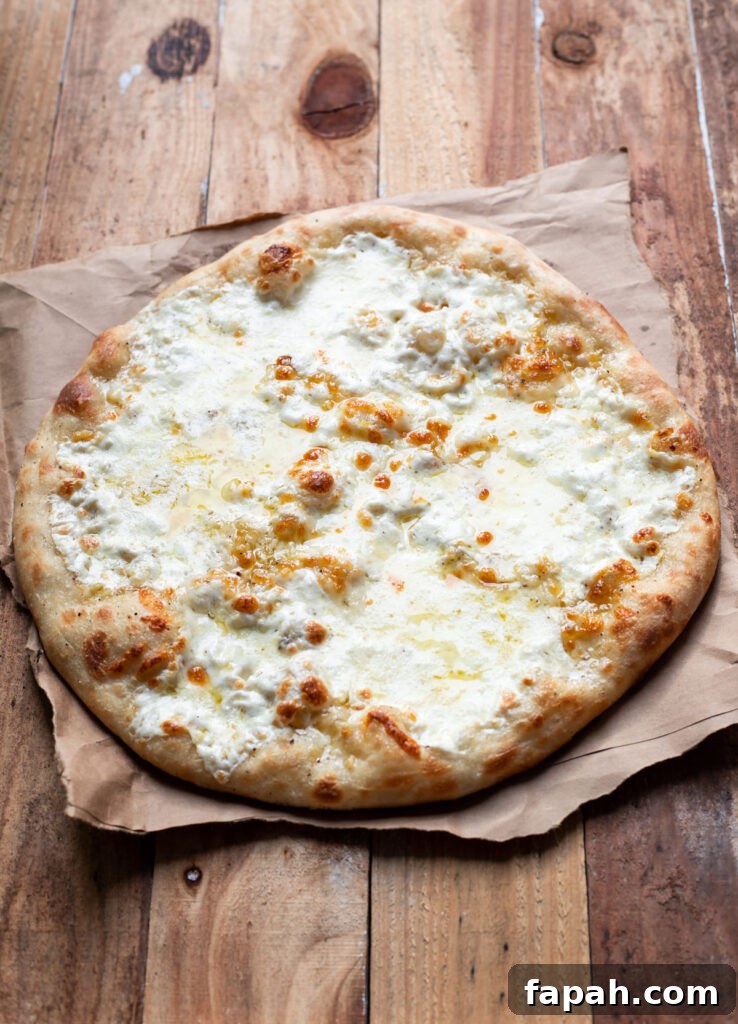 Caesar Salad Pizza Recipe: Crispy Romaine & Parmesan Pizza 3 cheese pizza with caesar salad and tomatoes on top