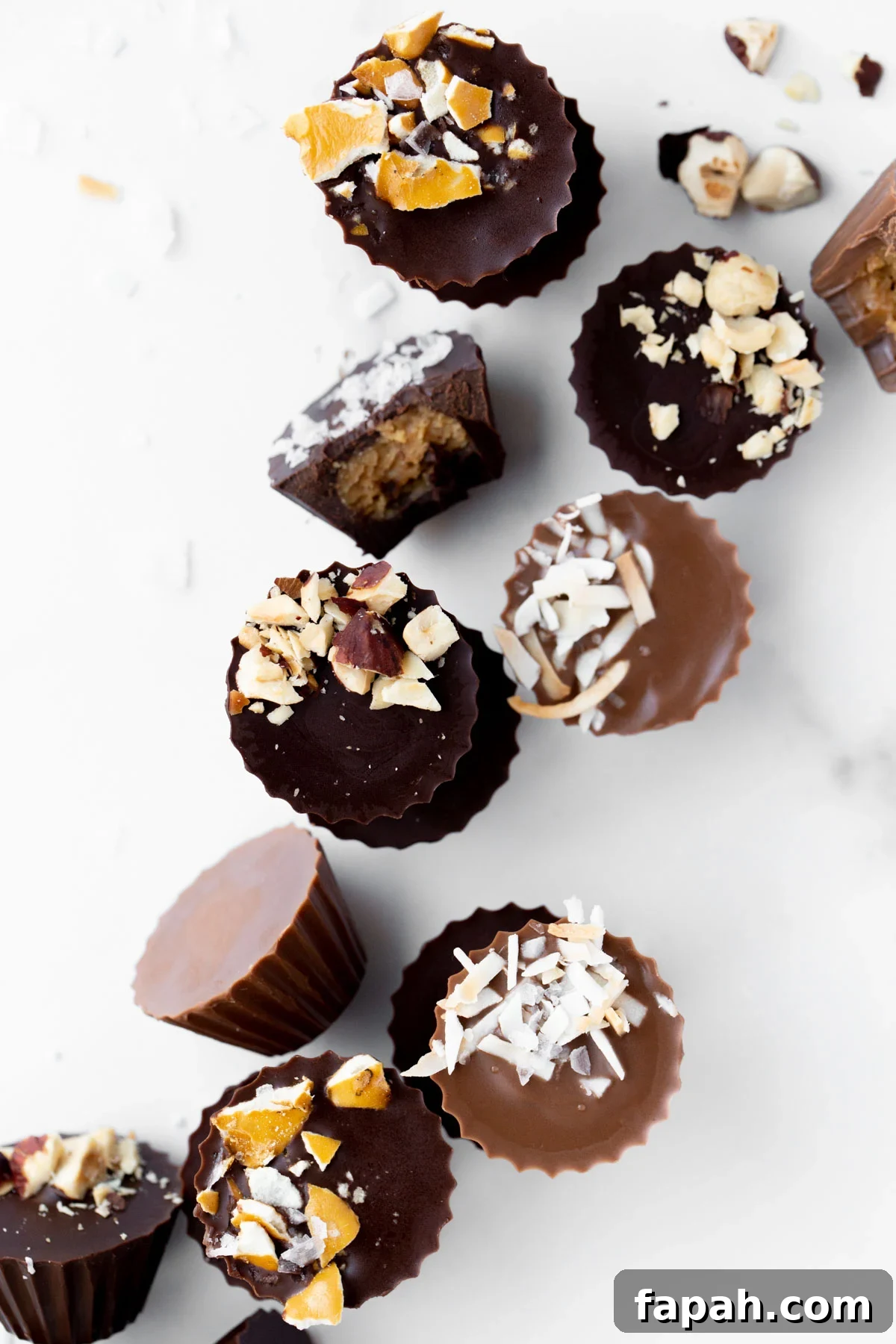 Mini Homemade Peanut Butter Cups: Simple No-Bake Recipe 4 overhead photo of mini peanut butter cups topped with crushed pretzels, toasted coconut, and macadamia nuts