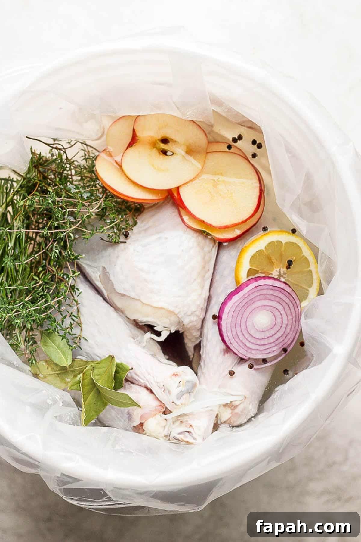 A whole turkey in a wet brine with herbs, apples and onions.