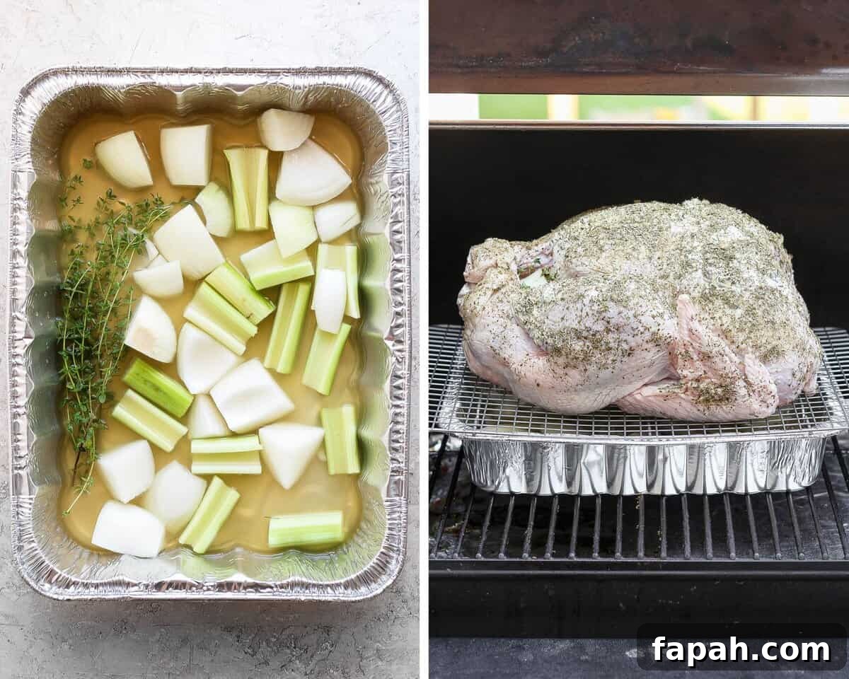 An aluminum pan filled with broth, onions, celery and herbs and a prepared turkey on a smoker about to be cooked.