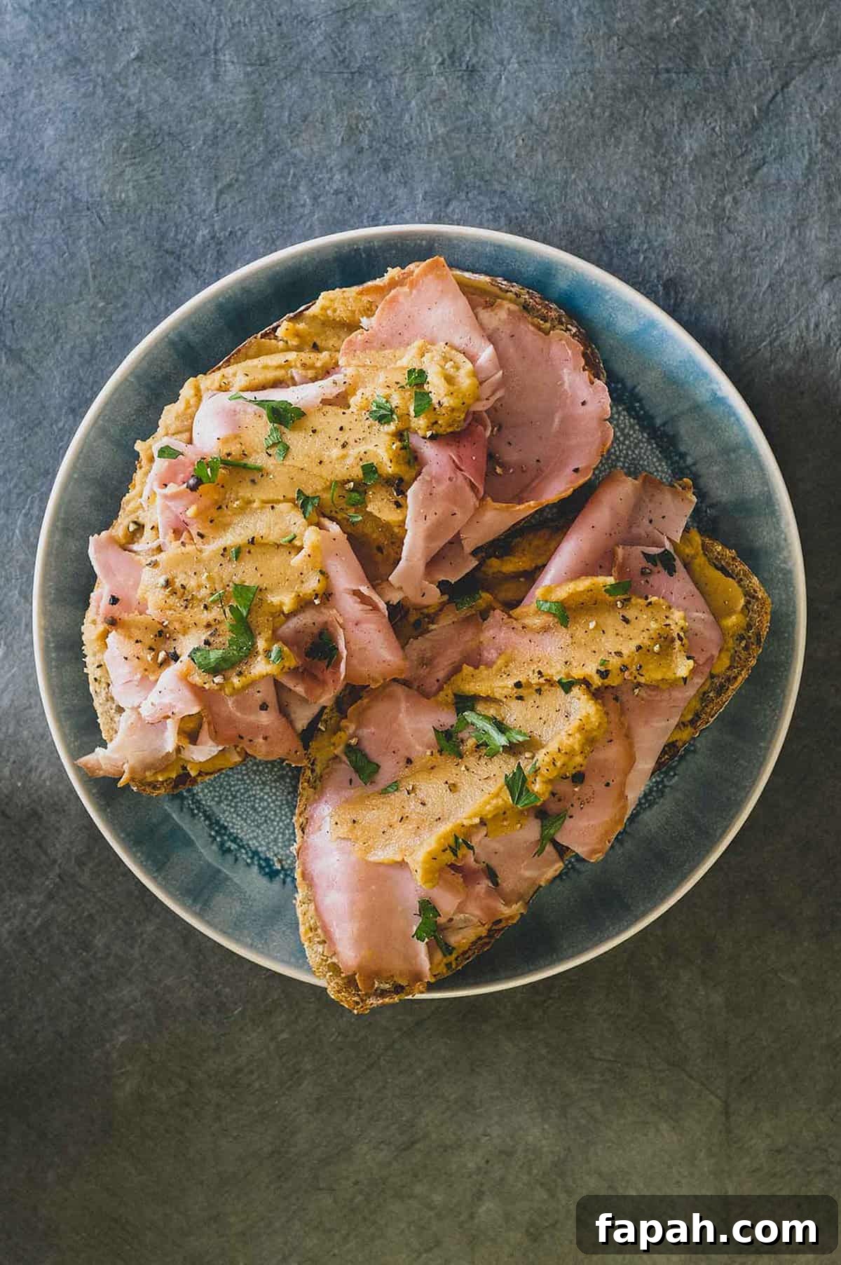 A an open sandwich with ham and pease pudding.