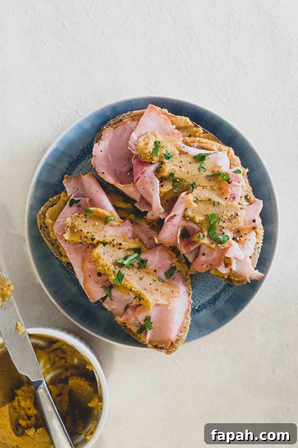 A an open sandwich with ham and pease pudding.