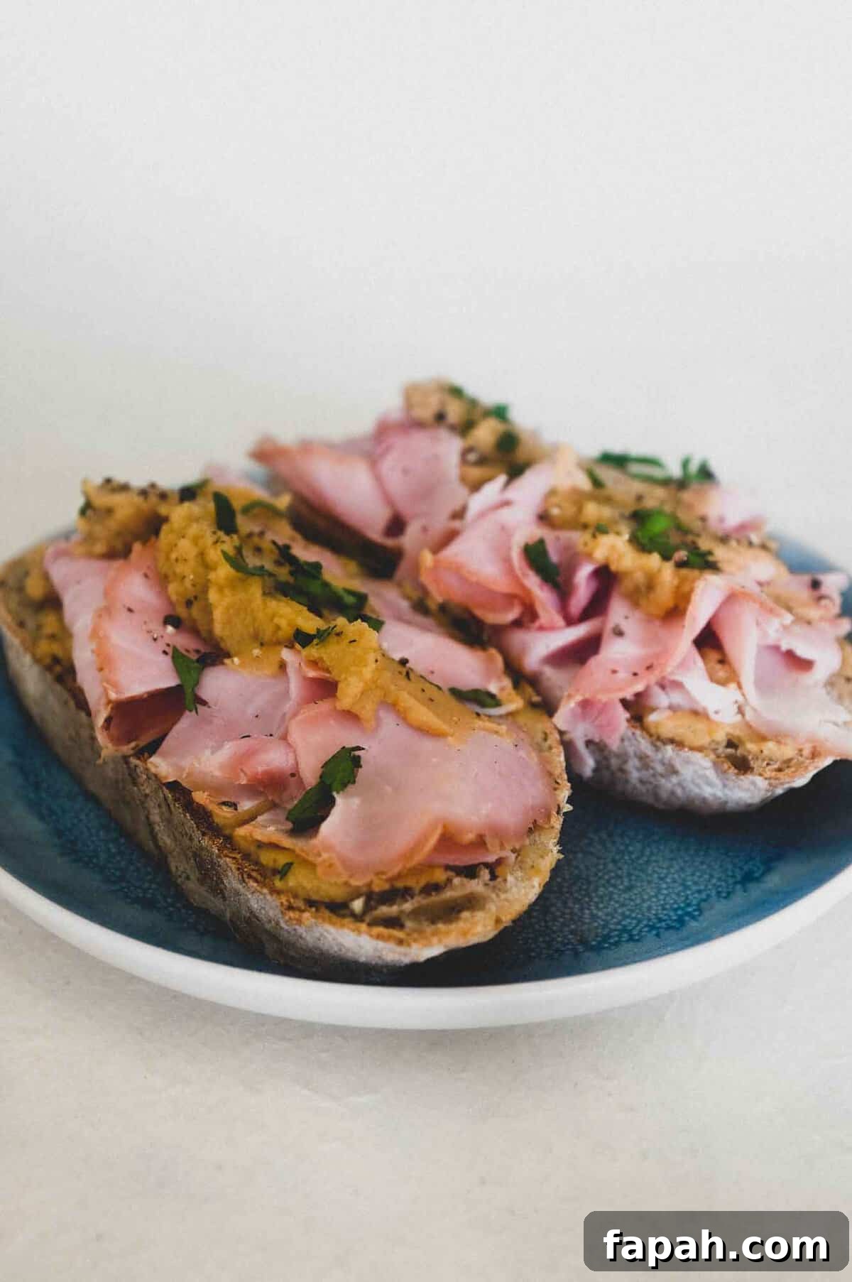 A an open sandwich with ham and pease pudding.