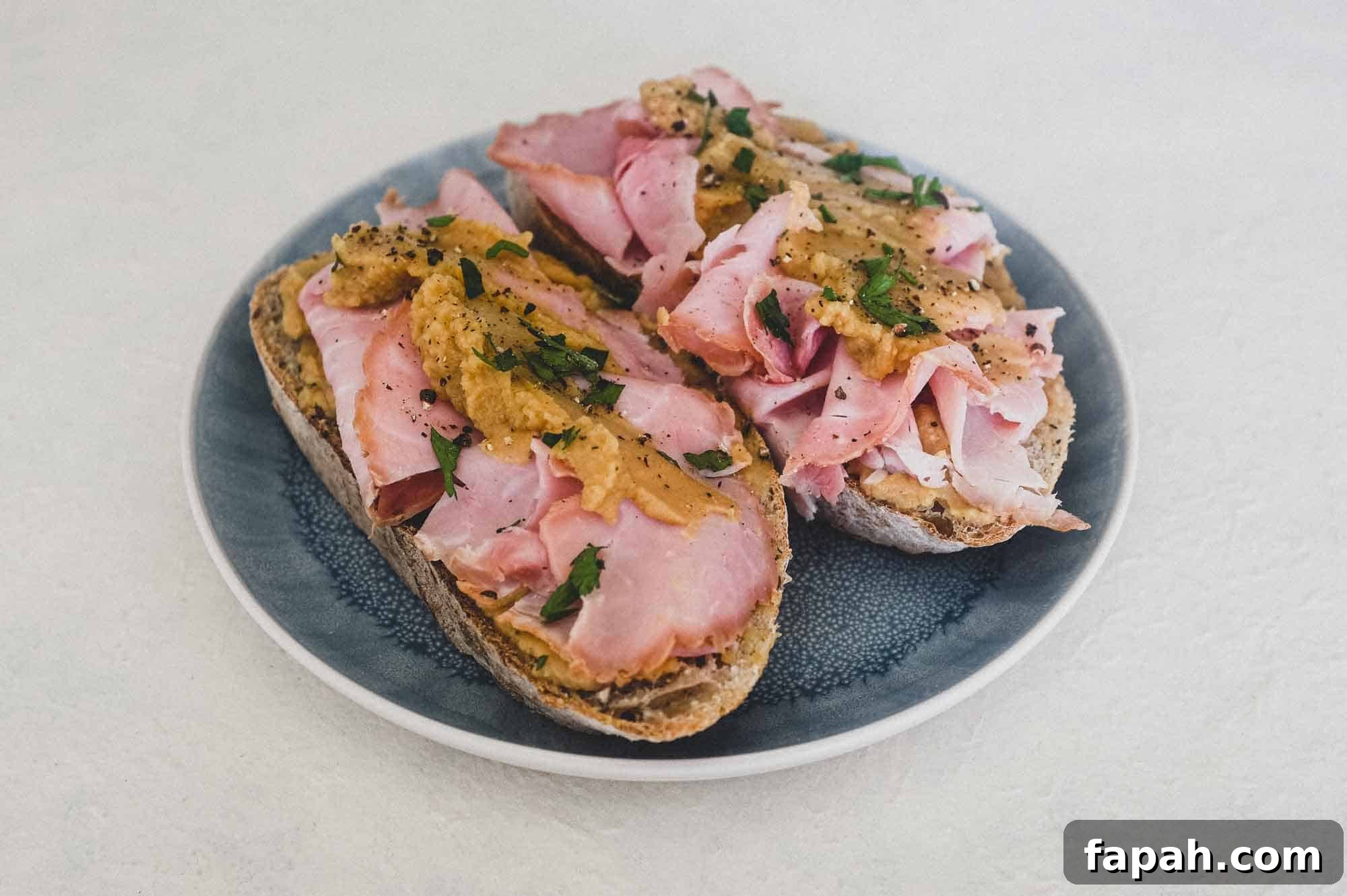 A an open sandwich with ham and pease pudding.