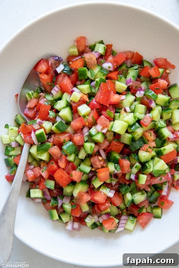 Israeli salad overhead shot of a plate of Israeli Salad with a spoon on the side