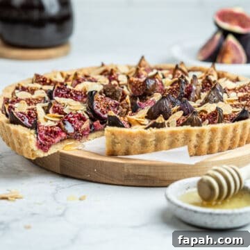 French fresh fig tart on a serving board lined with parchment paper.
