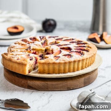 Plum frangipane tart on a serving board.