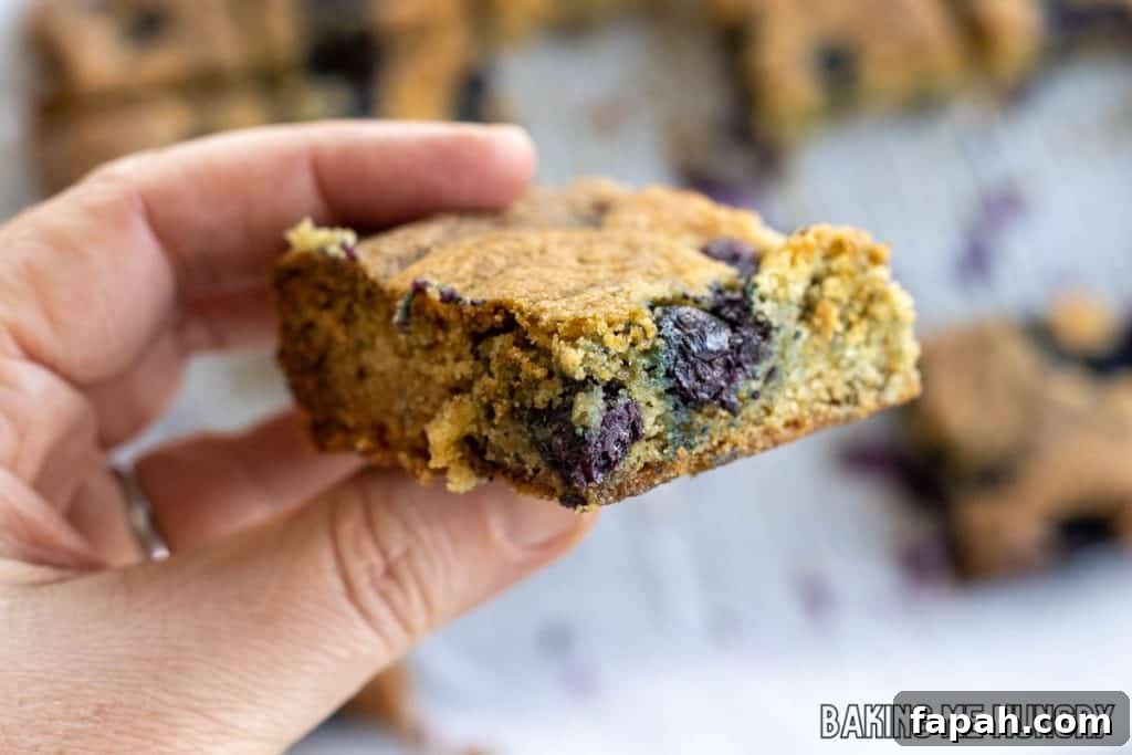 Chewy Blueberry Blondies with Lemon Glaze 12 blueberry blondie held by hand