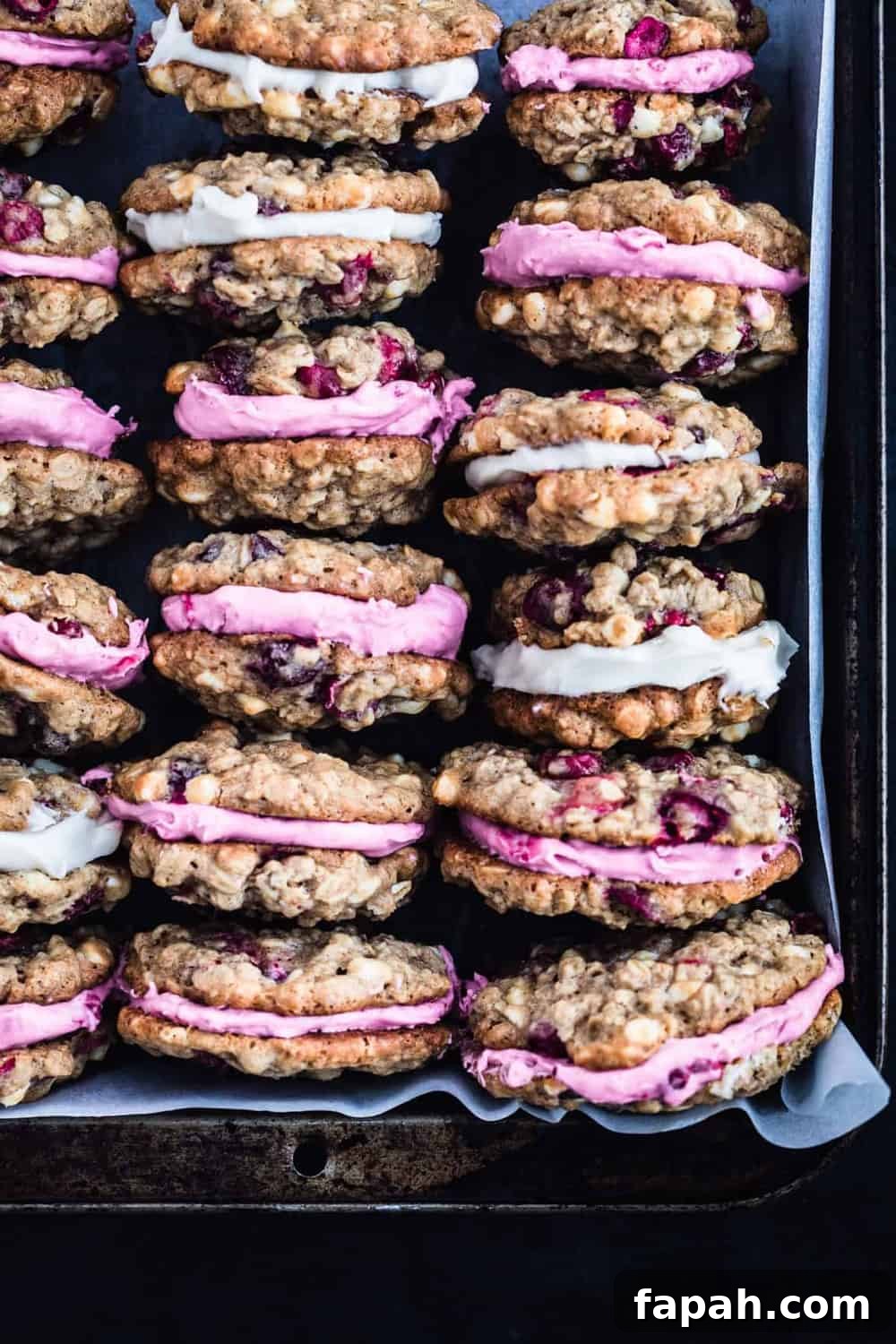 Rows of cranberry-stuffed cookies on parchment paper, overhead shot.