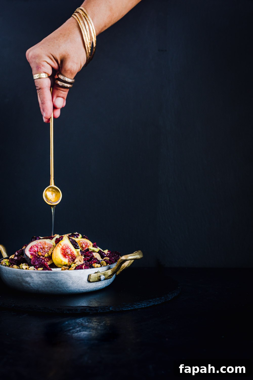 Honey drizzled over baked brie topped with figs, nuts and dried cranberries.