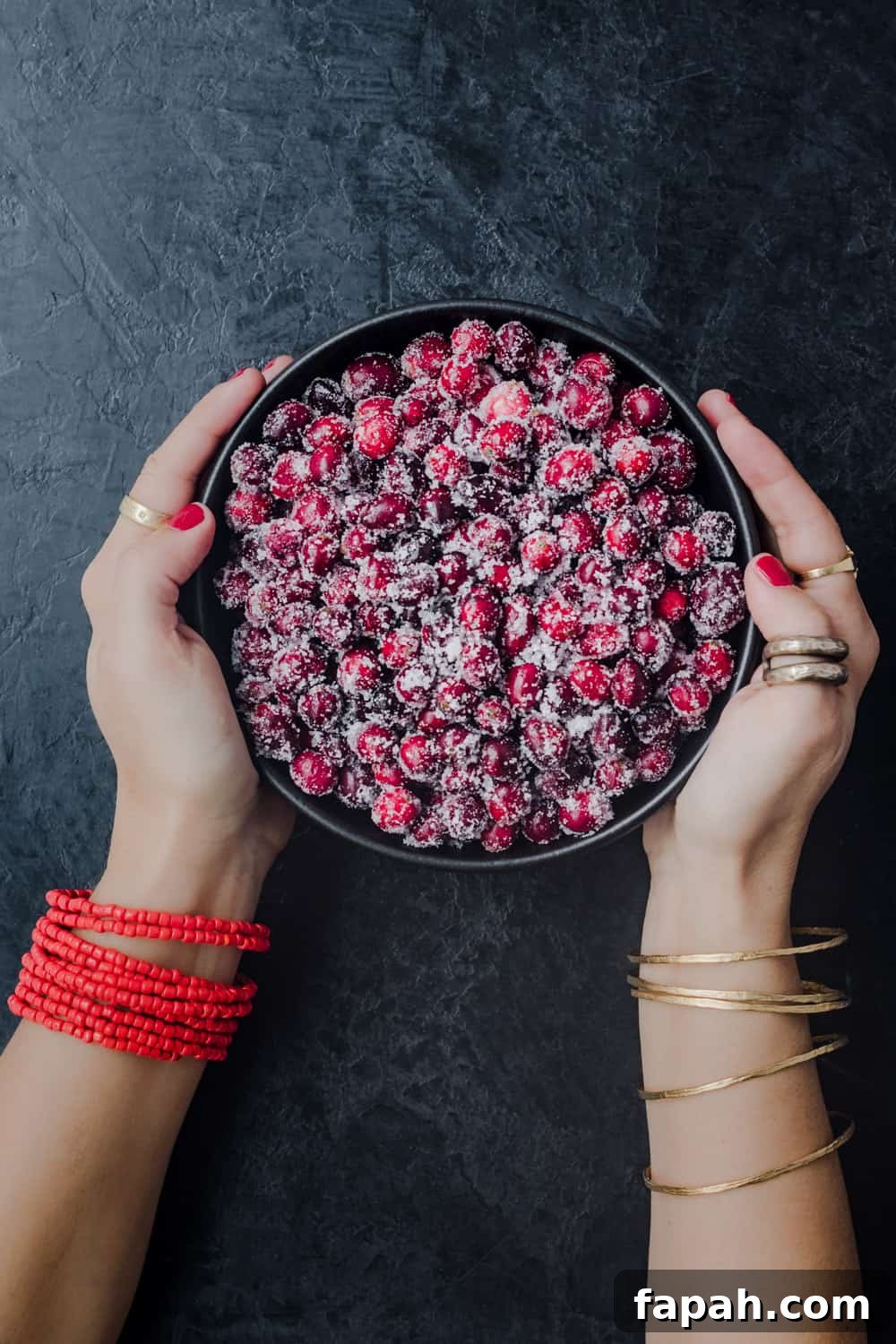 Daniela Gerson holding a bowl of black sugared cranberries; overhead shot.