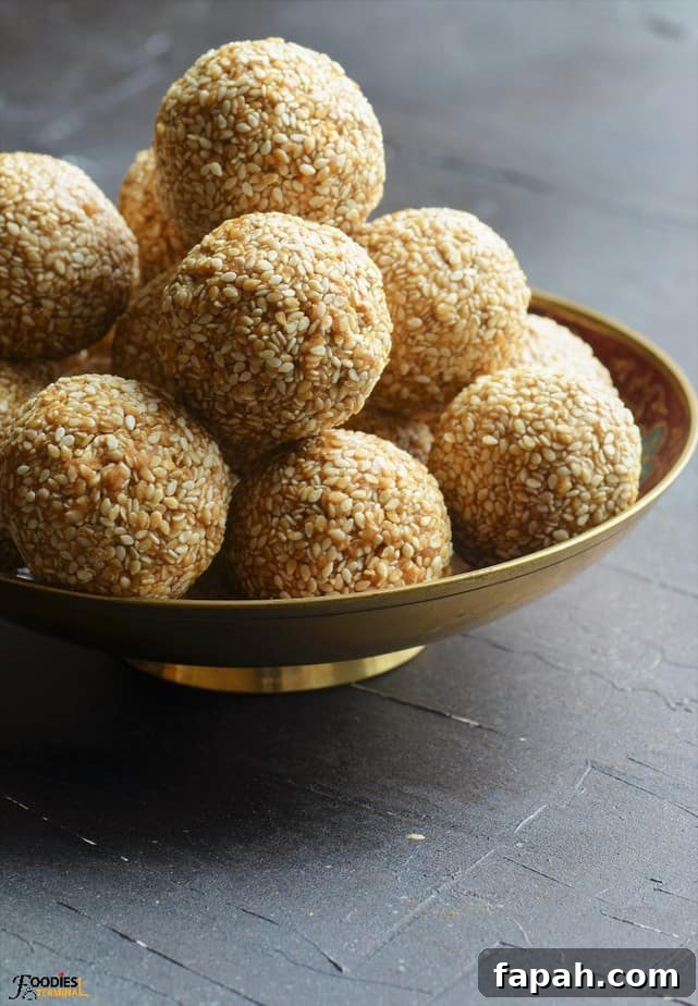 Sesame Ladoo Recipe: Traditional Til Laddu for Festivals 5 Sesame laddu in a gold bowl stacked on a pile