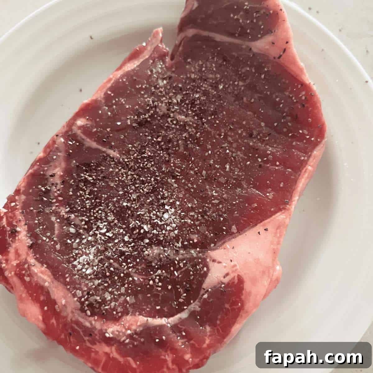 Seasoned air fryer steak with salt and pepper. 