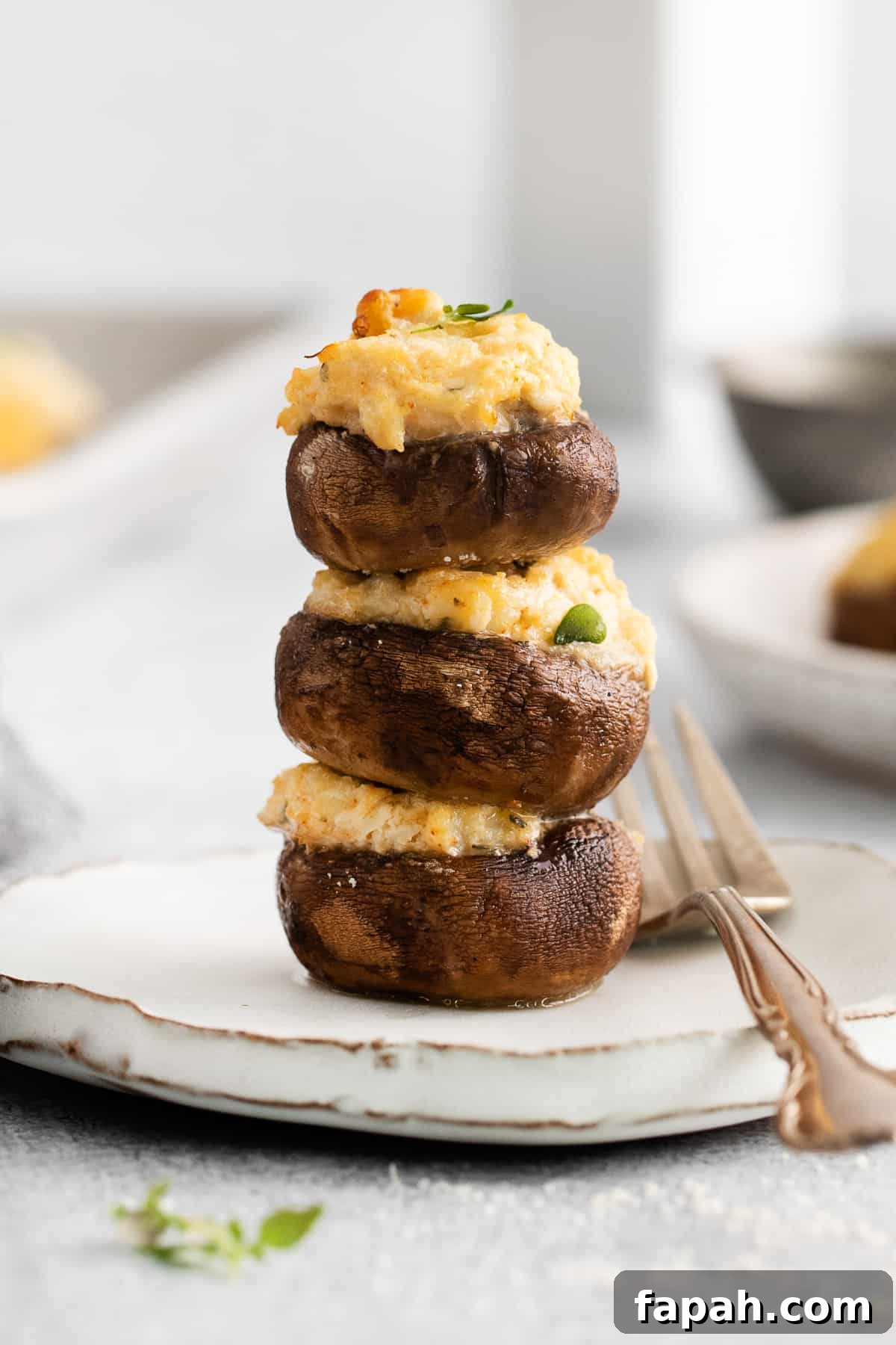 Crab stuffed mushrooms stacked on a plate.