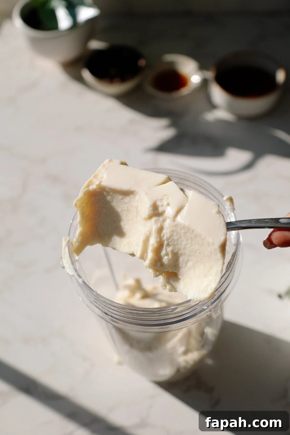 silken tofu being scooped into a blender for the chocolate pudding