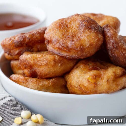 corn fritters stacked in a white bowl.