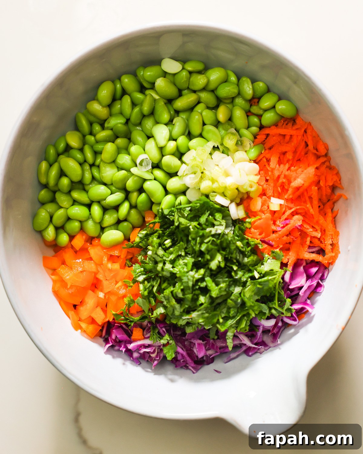Crisp Edamame Salad with Lemon-Ginger Vinaigrette 4 An overhead shot of a mixing bowl with the ingredients for edamame salad.