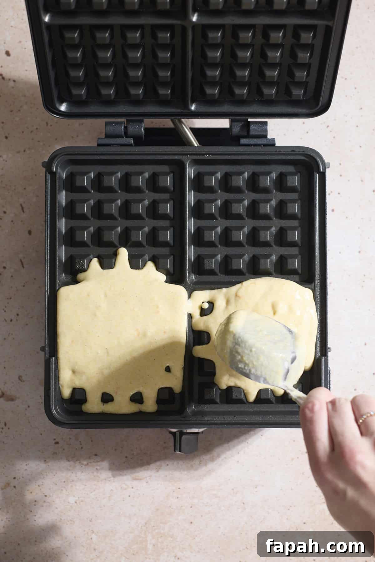 Batter being poured into a waffle iron.