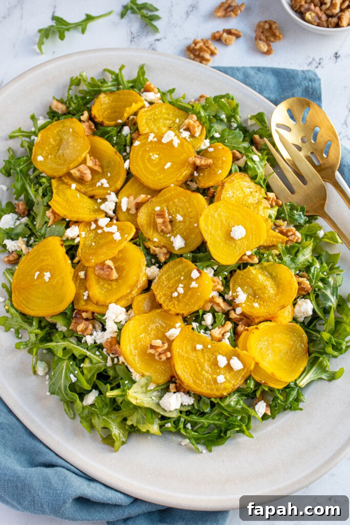 Arugula & Roasted Golden Beet Salad with Citrus Vinaigrette 2 A platter filled with arugula and topped with roasted beets, walnuts, and feta.