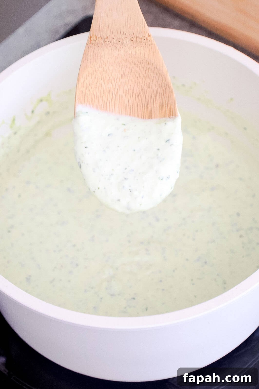 Creamy Jalapeño Ranch Pasta Recipe for a Flavorful Weeknight Meal 8 A spoon lifting thick and creamy jalapeño sauce from a saucepan.