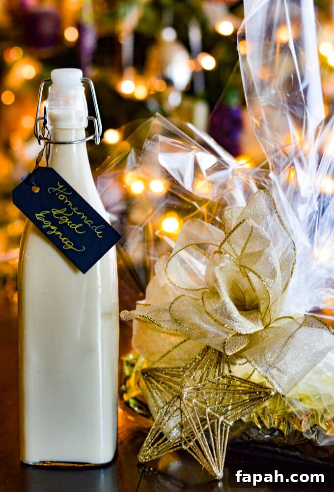 Salted Caramel Pumpkin Cake Roll Recipe for Fall Desserts 13 A gift wrapped pumpkin cake roll with cellophane wrap and a white ribbon. A gold star ornament is tied to the gift. A jar of homemade eggnog sits next to it.
