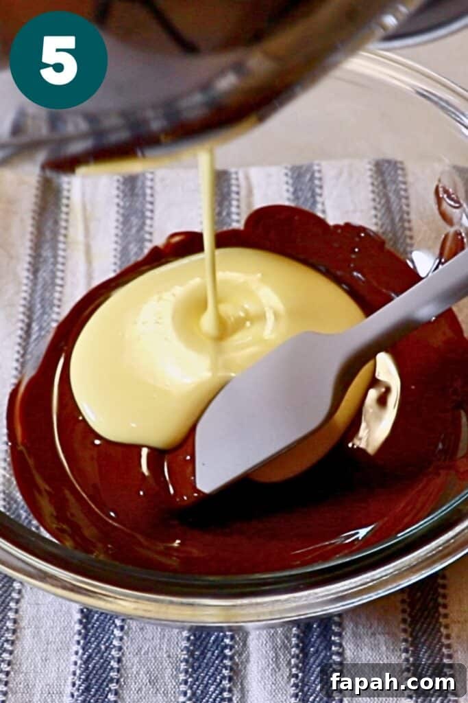 Decadent Chocolate Mousse Recipe for Silky, Airy Dessert 11 pouring pate au bombe into melted chocolate