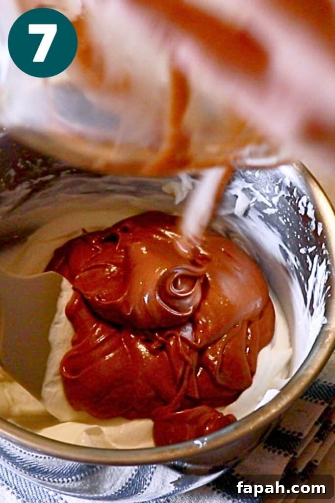 Decadent Chocolate Mousse Recipe for Silky, Airy Dessert 15 pouring the chocolate mixture into the remaining whipped cream