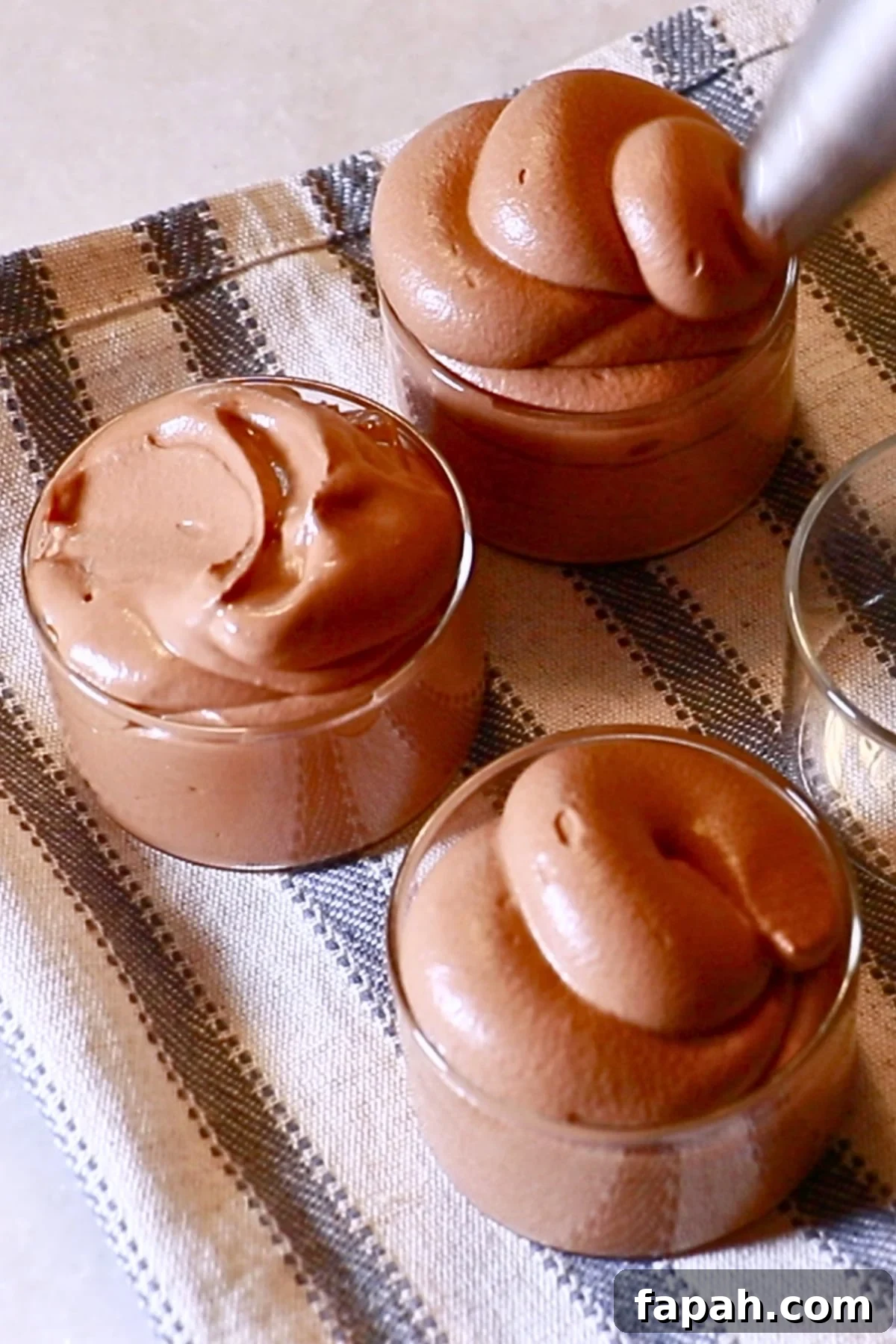 Decadent Chocolate Mousse Recipe for Silky, Airy Dessert 4 piping chocolate mousse into glasses