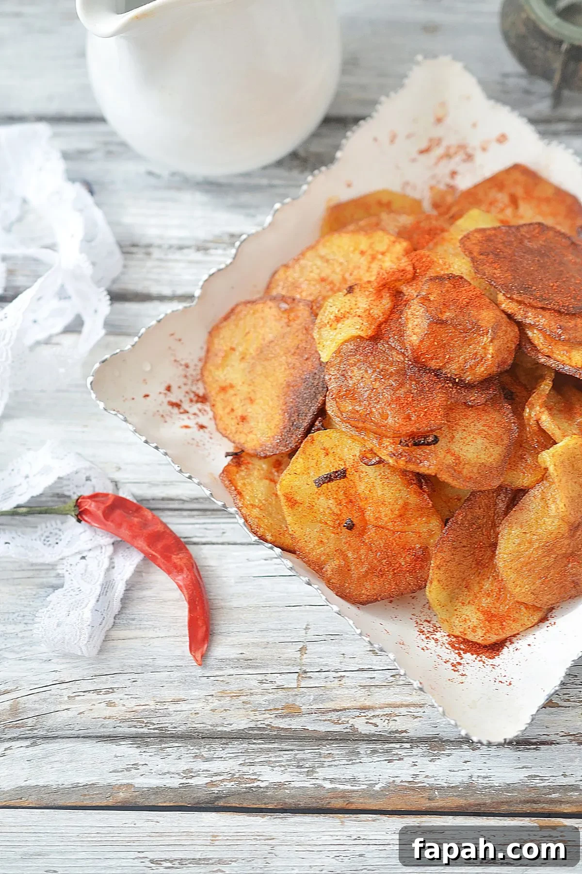 Cookie down on a square plate of fried potatoes and onions.